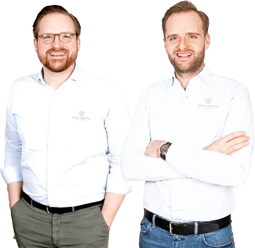 Die Geschäftsführer von Voigt Dental, Jan-Willem Voigt und Maximilian Voigt, lächelnd in weißer Praxisbekleidung
