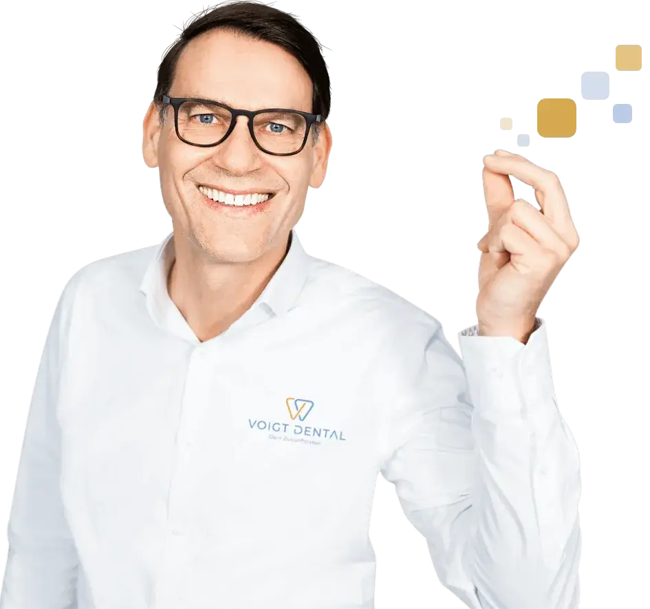 Zahnarzt von Voigt Dental lächelt freundlich und weist auf wichtige Informationen hin.