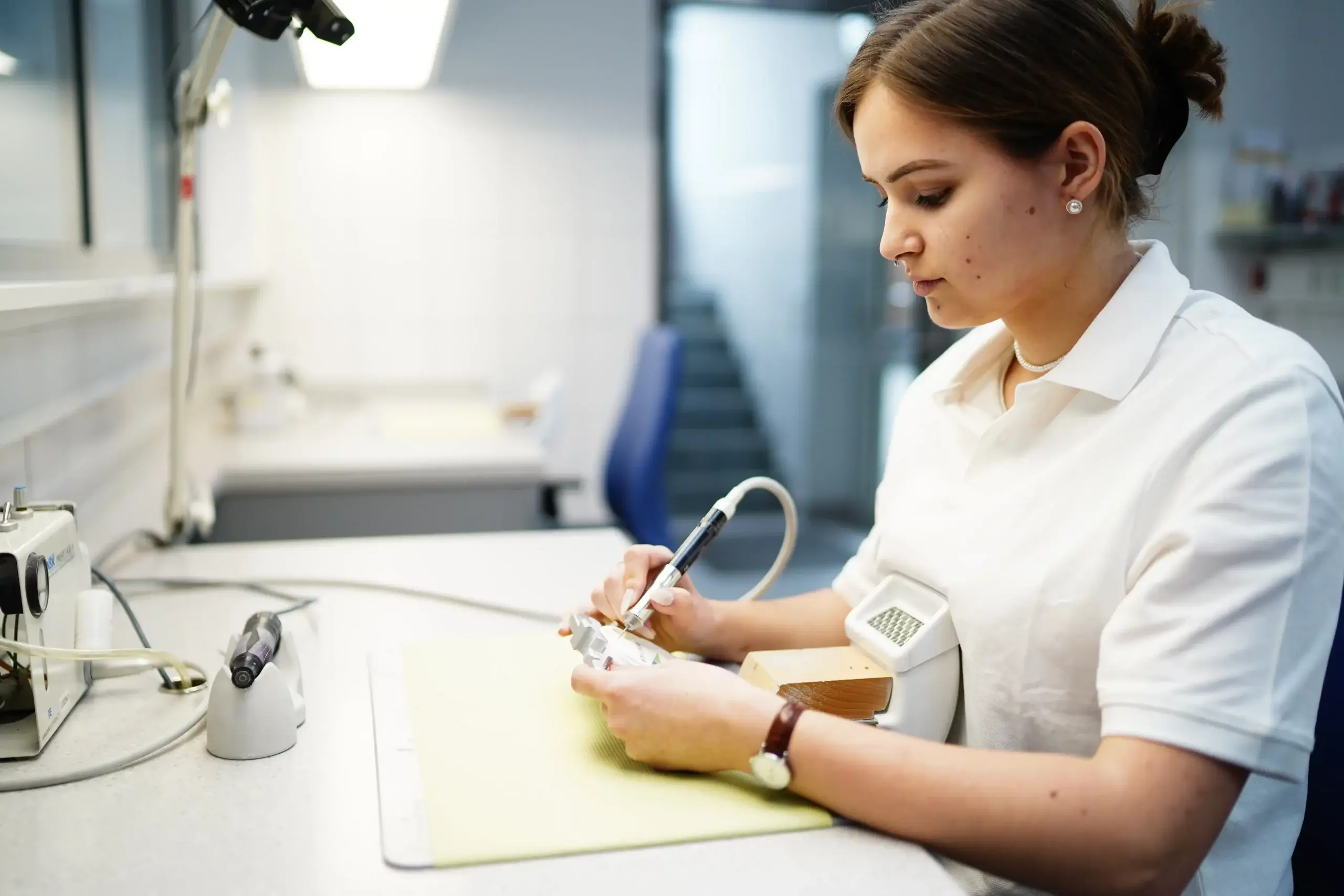 Präzisionshandwerk im Dentallabor Voigt Dental: Individuelle Anpassung von hochwertigem Zahnersatz durch eine Fachkraft.